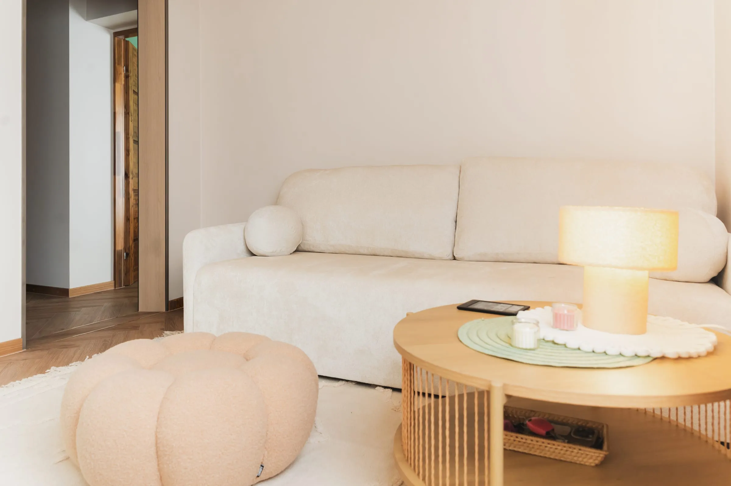 Detal salonu Apartamentu Boho z sofą, stolikiem i pufą